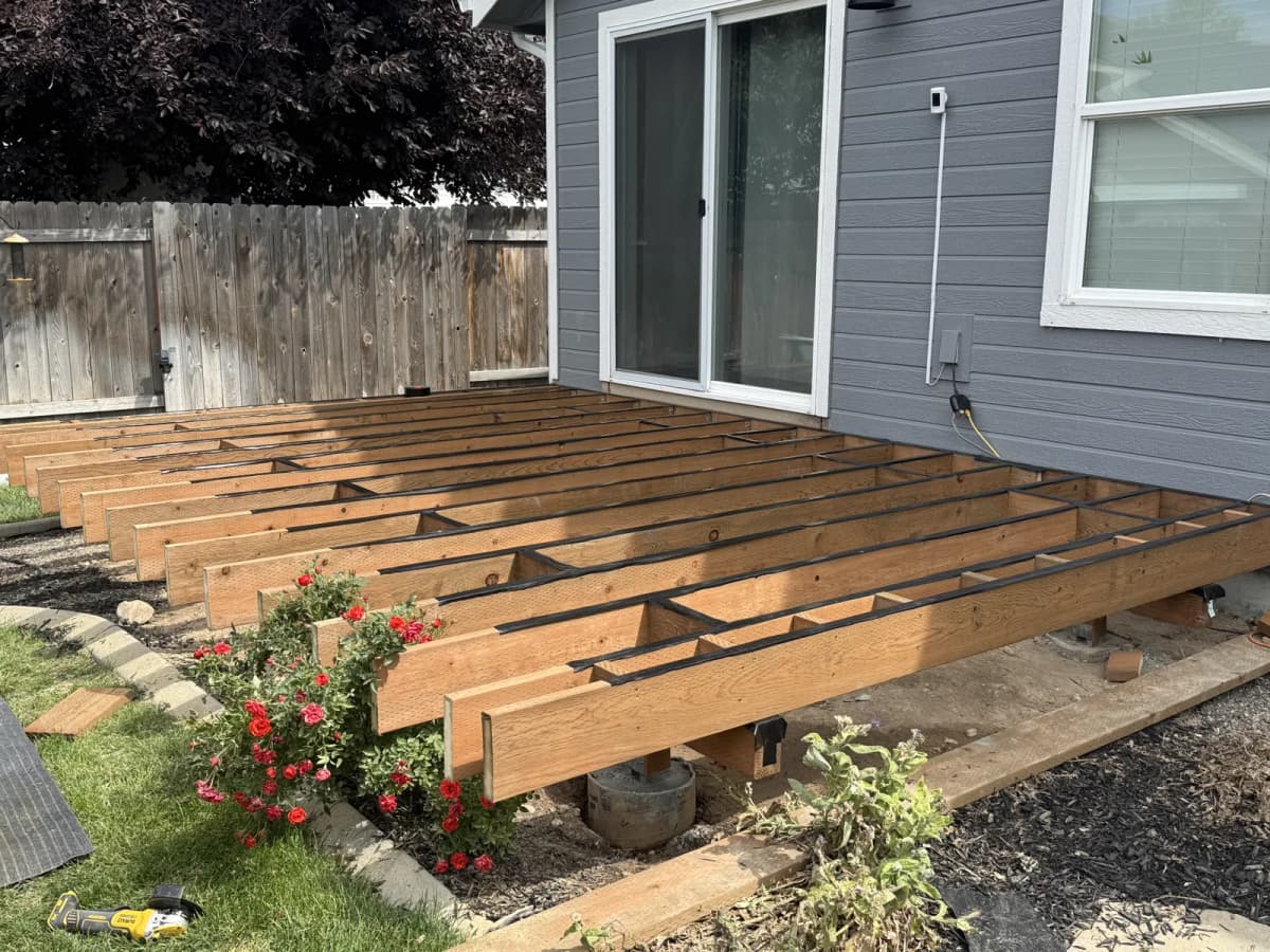 New pressure-treated 2x8 deck frame on post bases and concrete footings in Boise
