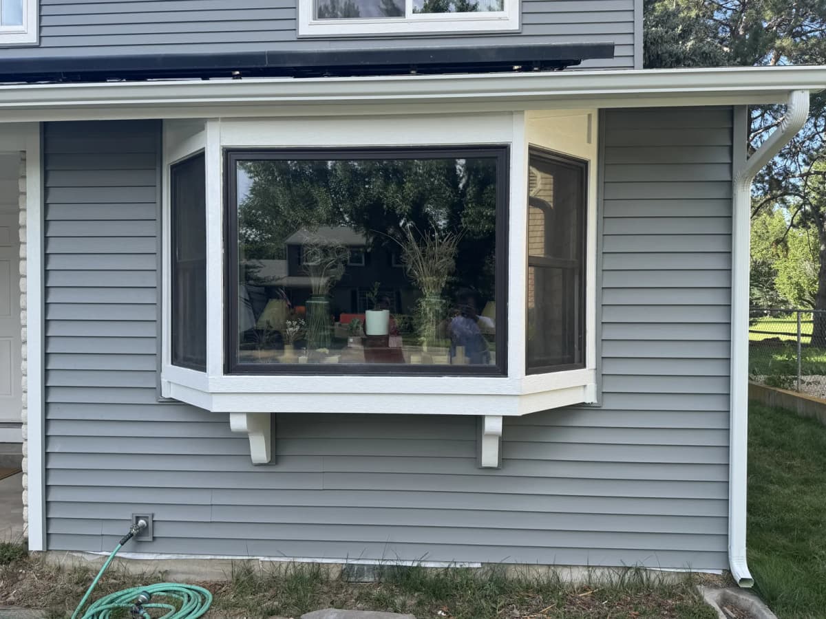 New bay window with white trim set into gray vinyl siding on a Boise home