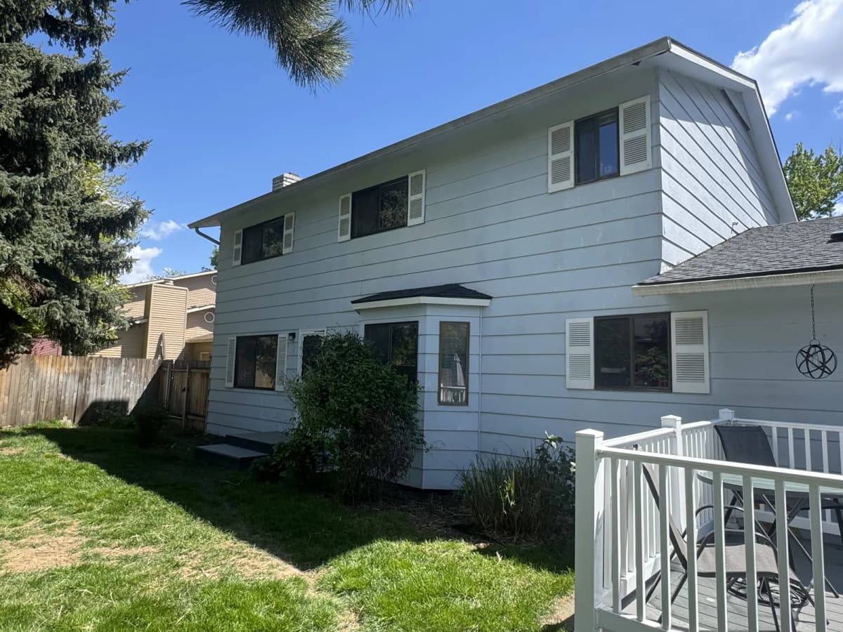 Side of a Boise home with original white siding, shutters and bay window before remodel