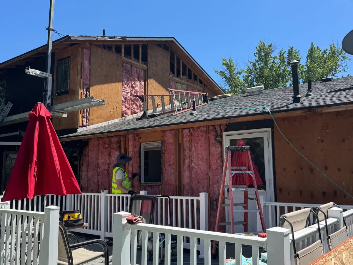 Old siding being removed from the rear addition of a Boise home, opening up the wall