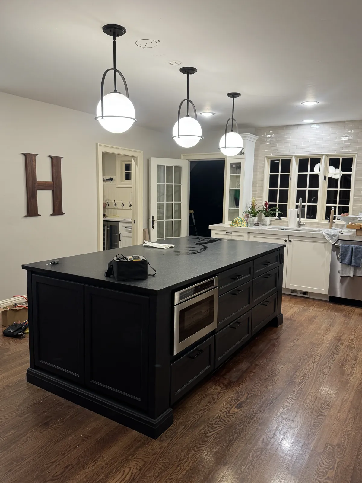 New black shaker kitchen island with matte black quartz countertop, drawers and a built-in microwave drawer in Eagle, Idaho