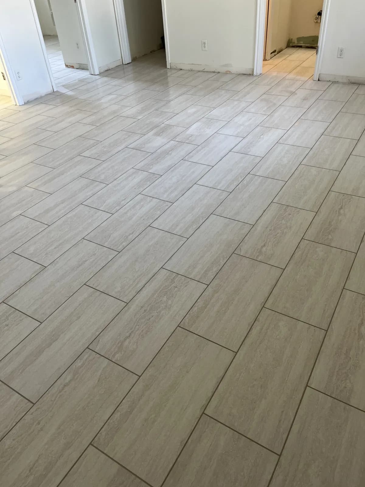 Finished basement tile floor running through a Meridian basement