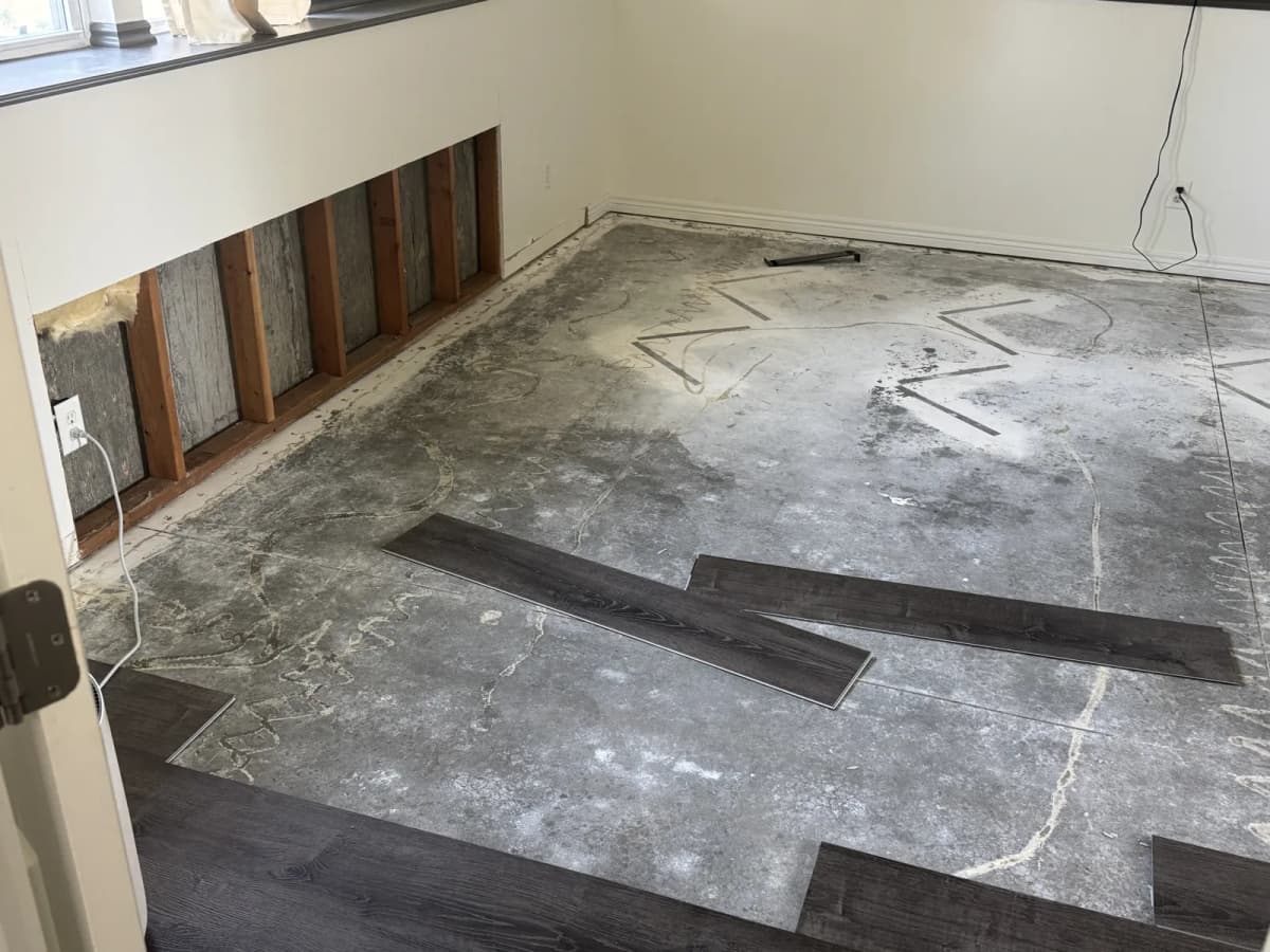 Meridian basement with old vinyl plank flooring pulled up, exposing a cracked concrete slab