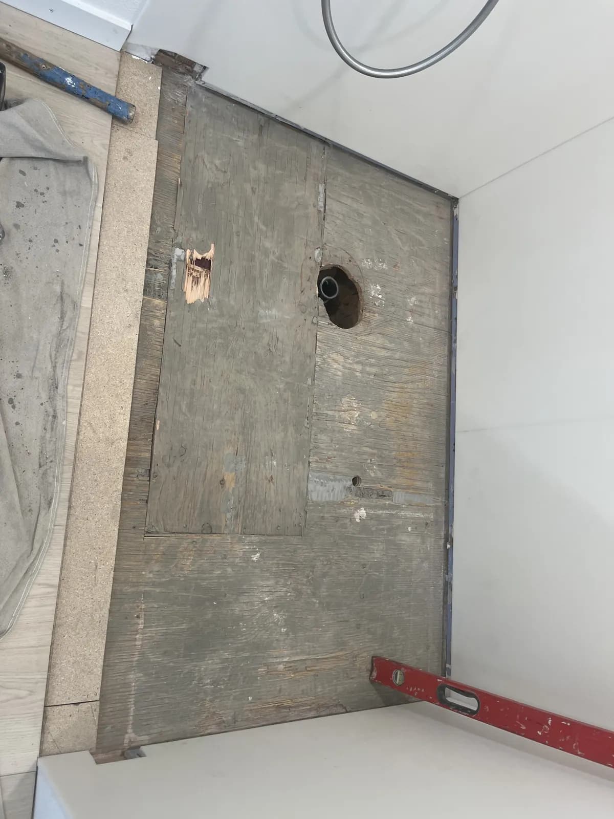 Shower subfloor and drain opening after the old pan and curb were removed in Mountain Home