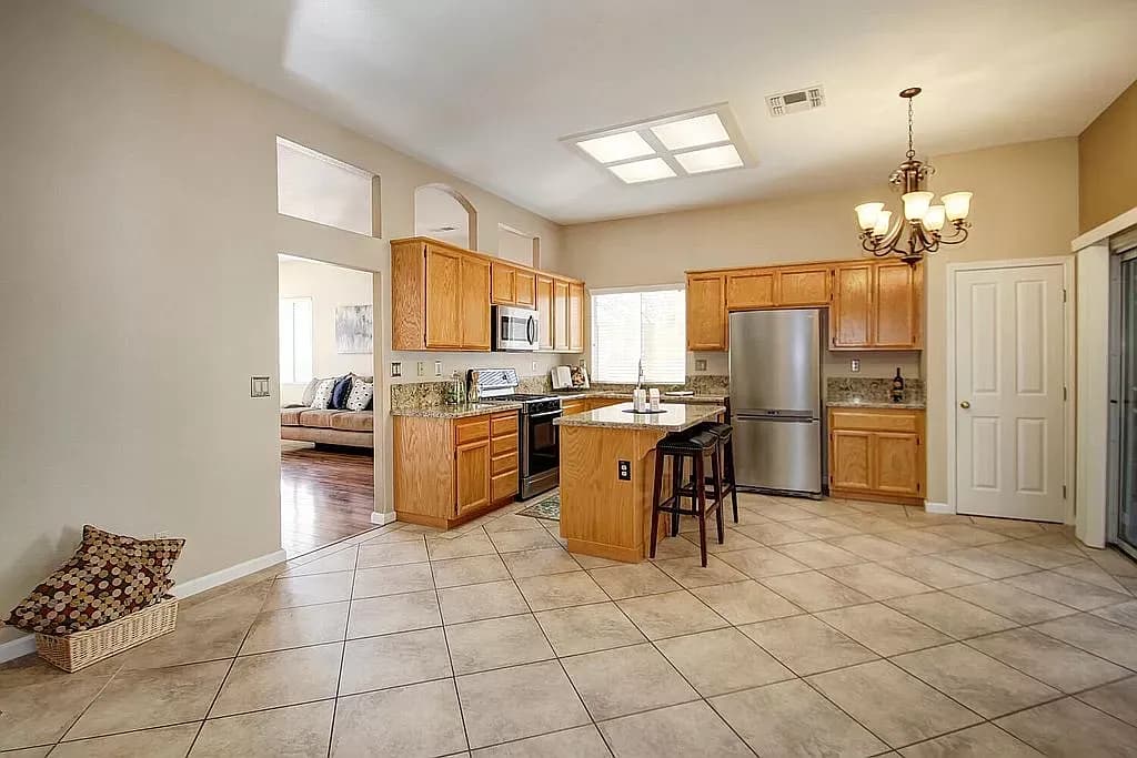 The kitchen before remodeling, with original oak cabinets and tile floor
