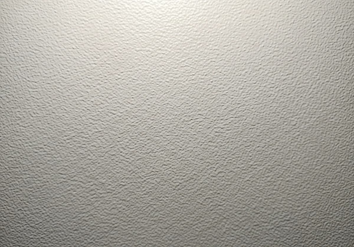Close-up of a fine orange-peel ceiling texture with even dimpling on a freshly finished ceiling