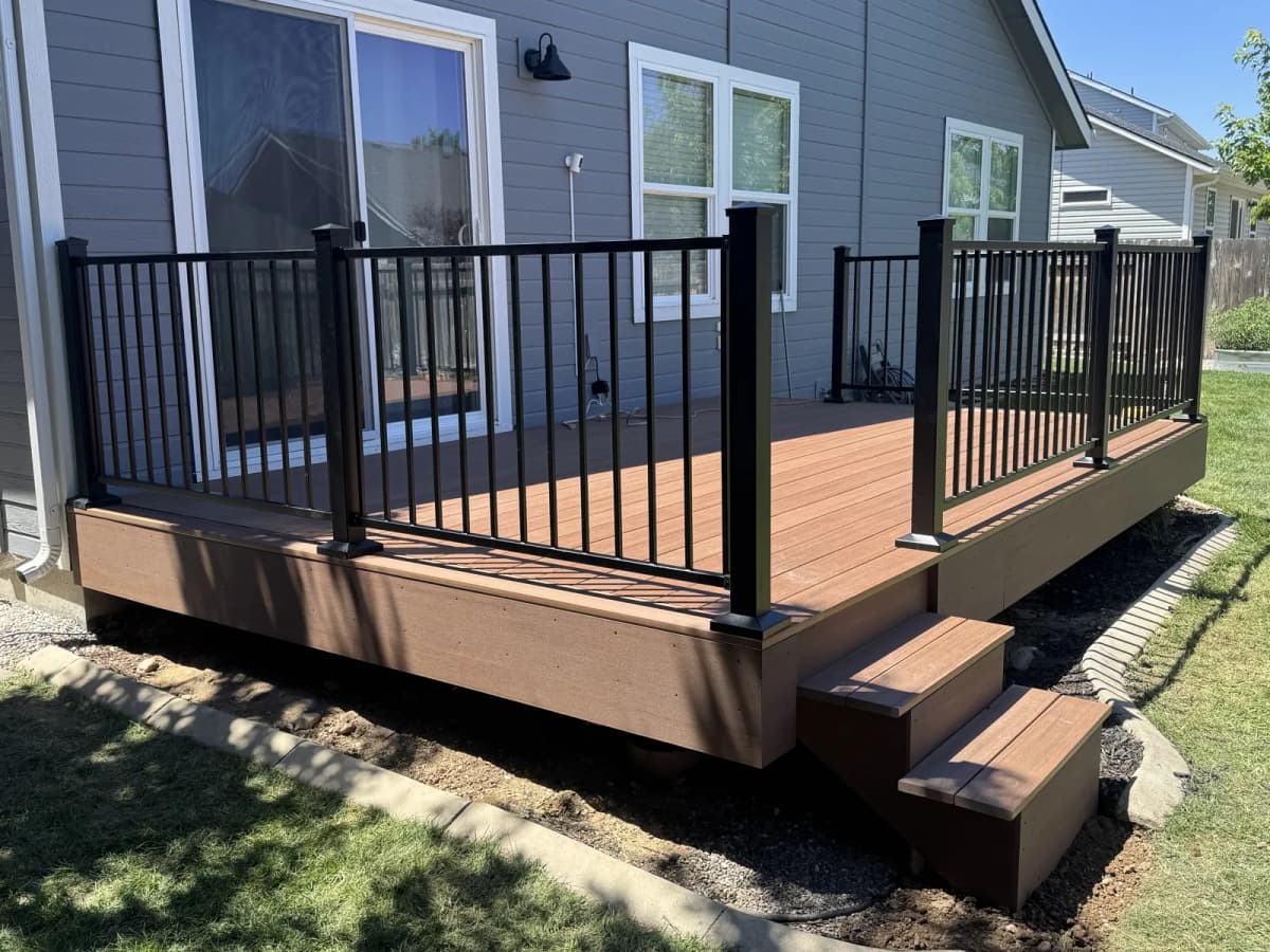 New TimberTech AZEK composite deck with black metal railing and steps in a Boise backyard