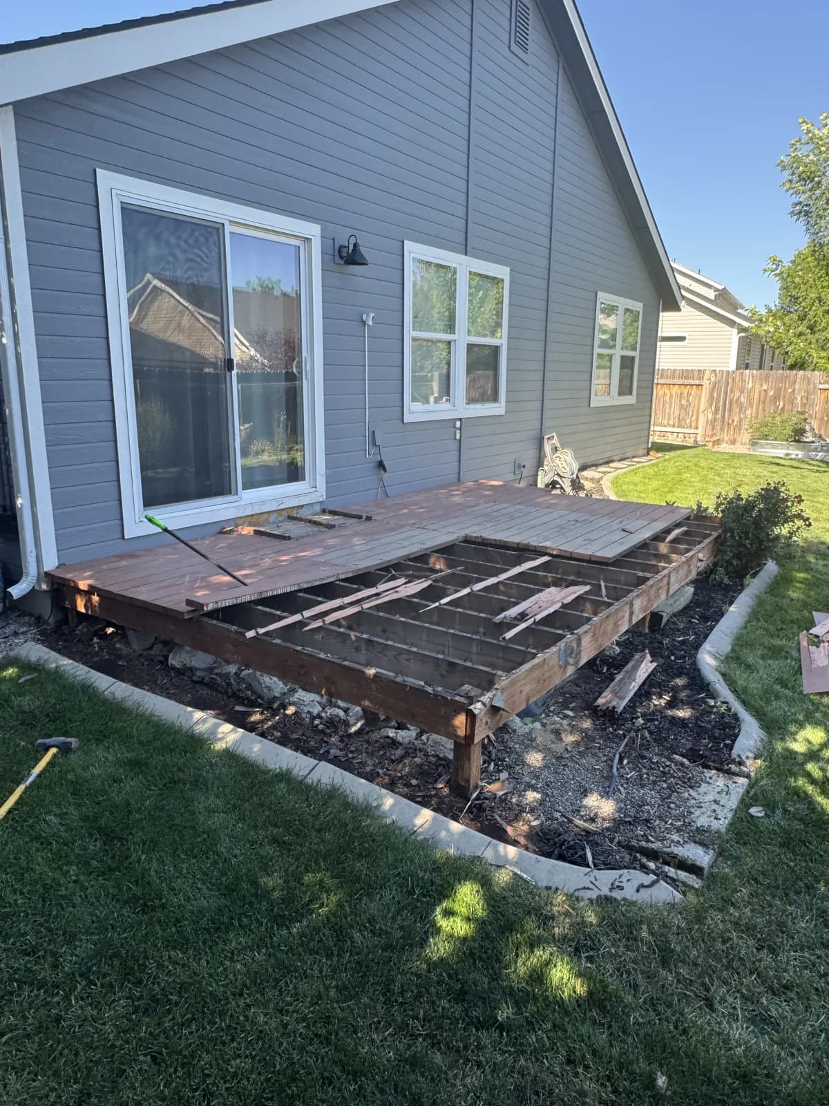 Old deck boards removed exposing the original deck frame at a Boise home